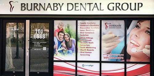 Burnaby Dental Group storefront exterior showing entrance door and window displays with family dentistry services information and contact details at 101-6688 location