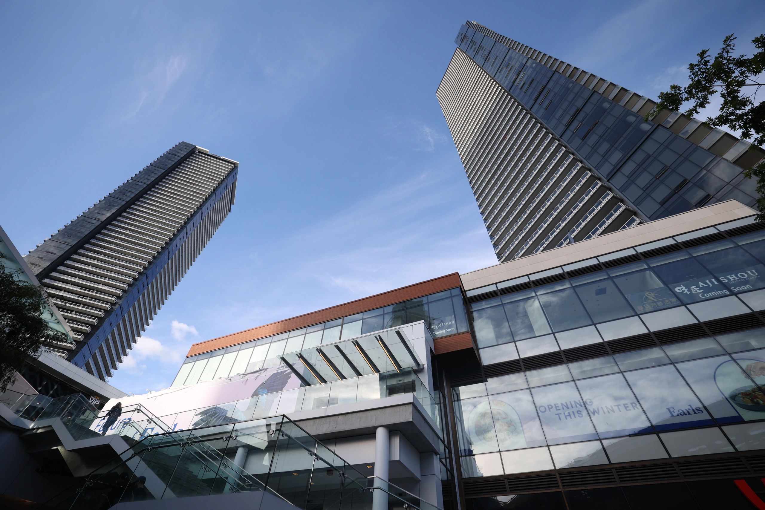 Tall residential towers and modern commercial building with glass facade in Burnaby downtown
