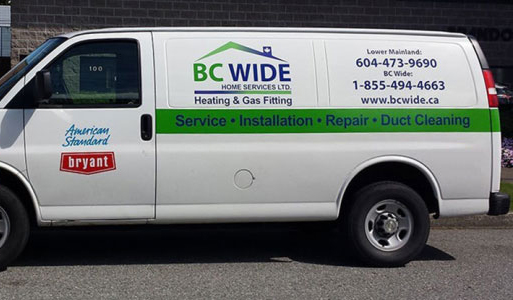 BC Wide Home Services Ltd service van parked against brick wall, displaying company branding, contact information for Lower Mainland and toll-free number, and services offered including heating, gas fitting, installation, repair, and duct cleaning in Burnaby and surrounding areas