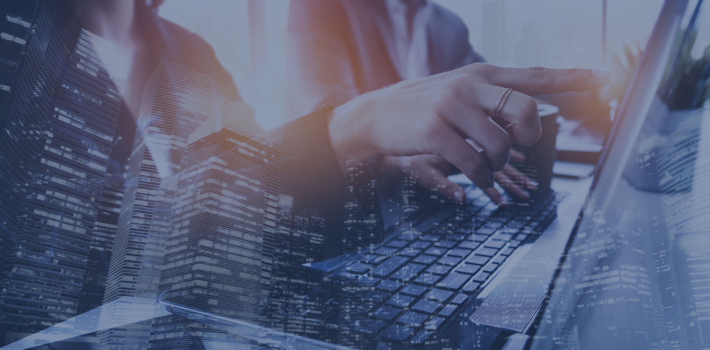 Professional hand typing on laptop keyboard with double exposure of city skyline and office buildings