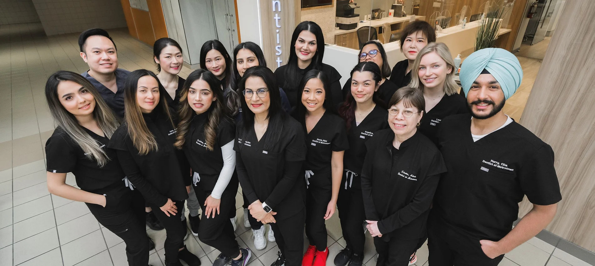 Team of dental professionals in black uniforms posing together at Metrotown dental office in Burnaby