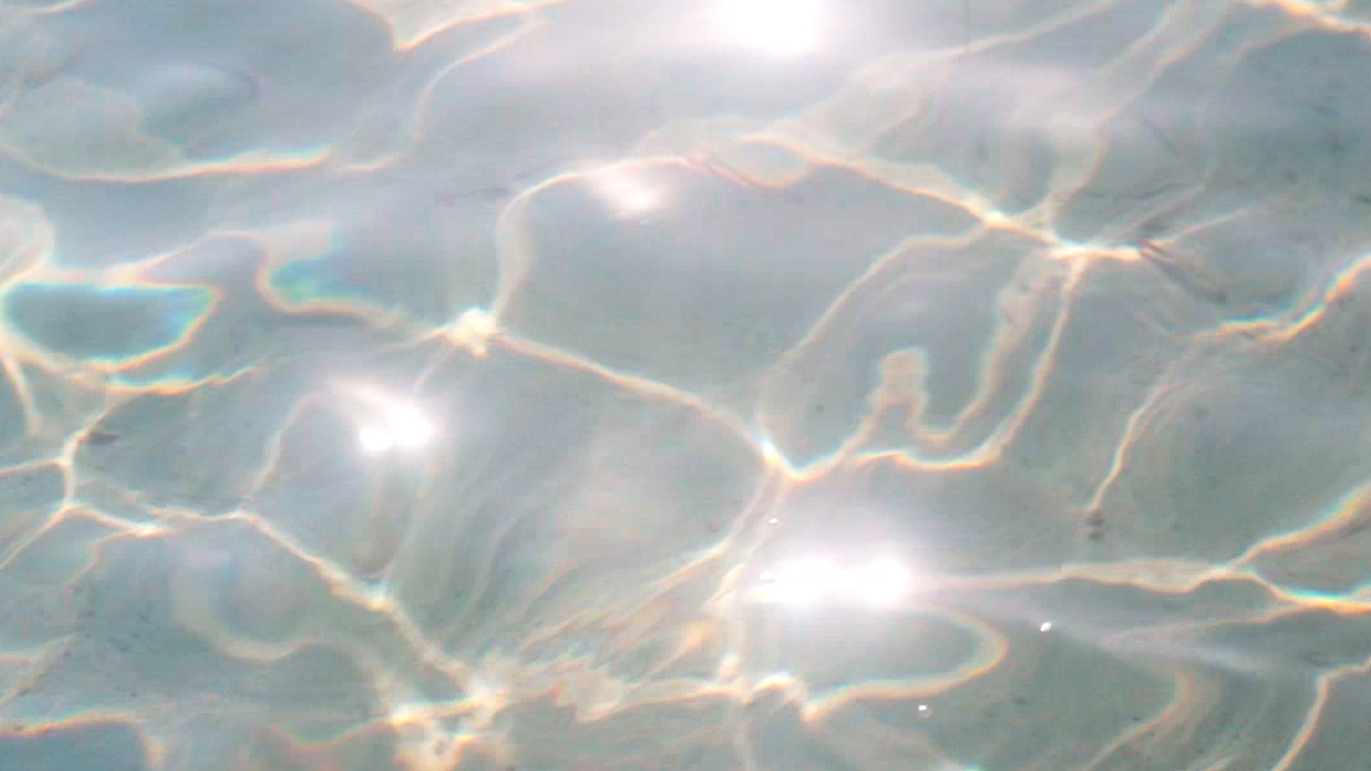 Underwater caustic light pattern with golden wavy lines reflecting through water onto a surface